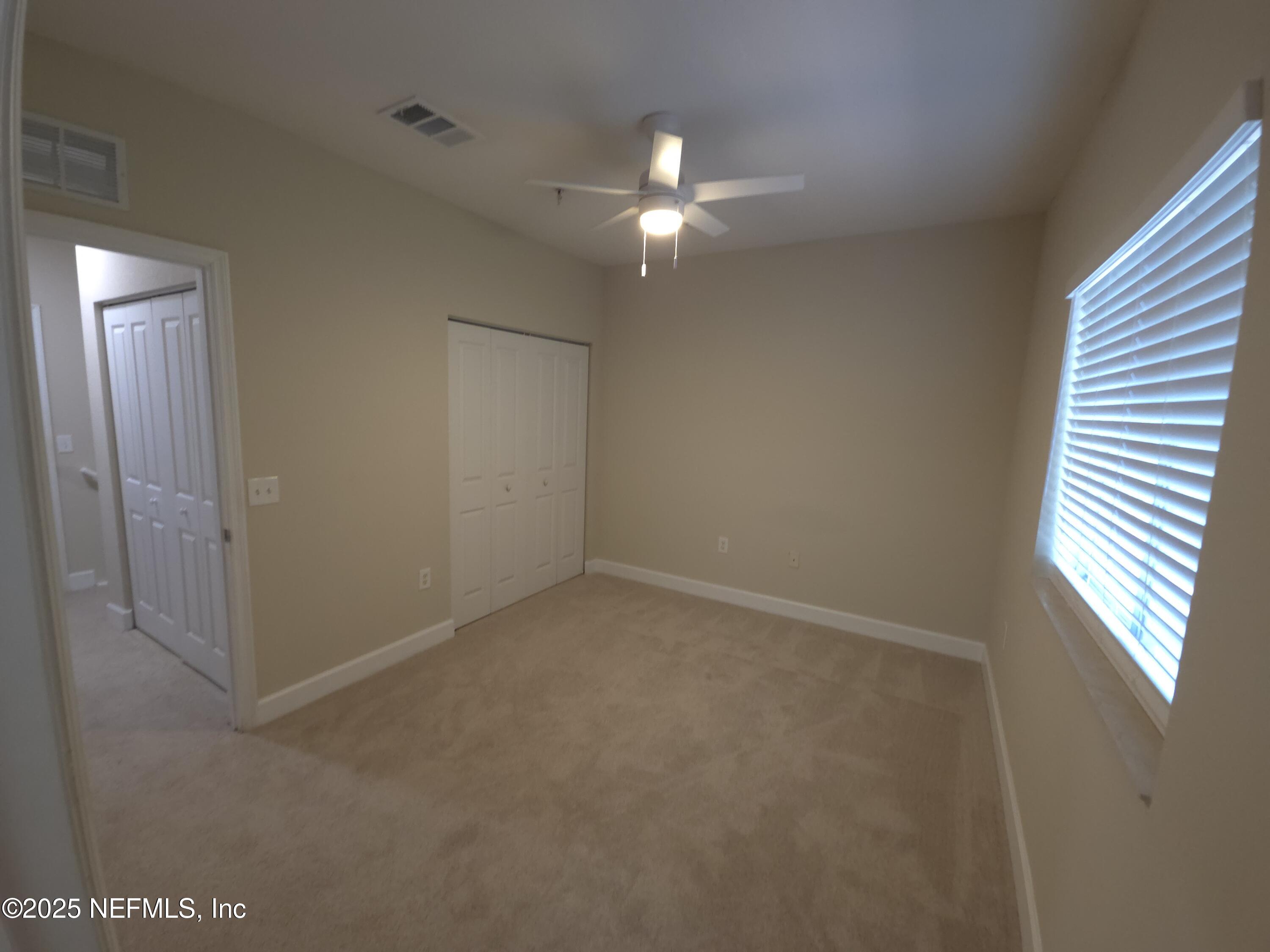 9745 Touchton Road, Unit 427 Jacksonville, FL 32246 - Photo 29 of 52 an empty room with windows and fan