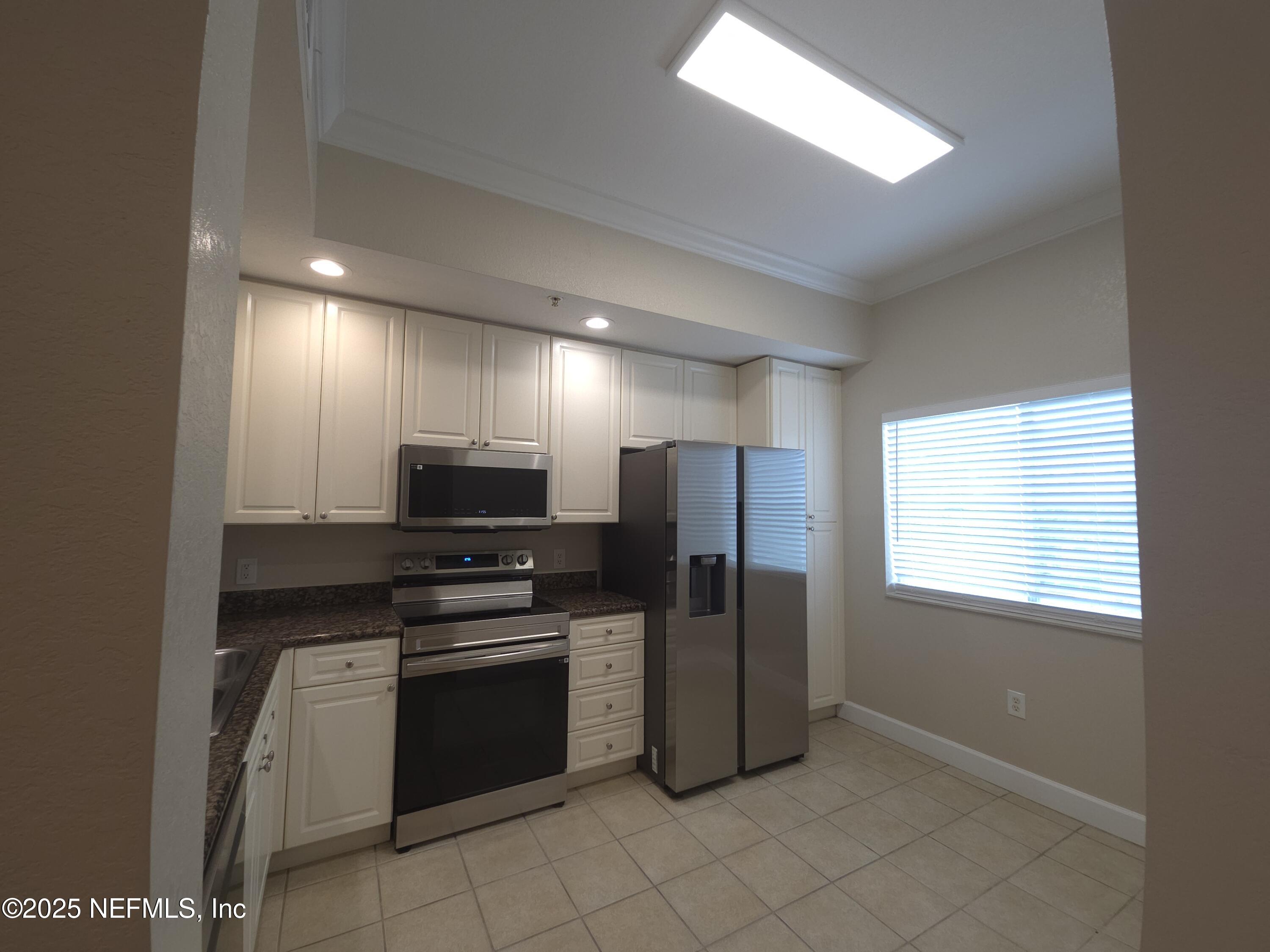 9745 Touchton Road, Unit 427 Jacksonville, FL 32246 - Photo 6 of 52 a kitchen with a refrigerator and a stove top oven
