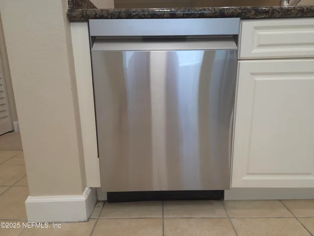 a kitchen with stainless steel appliances white cabinets and a refrigerator