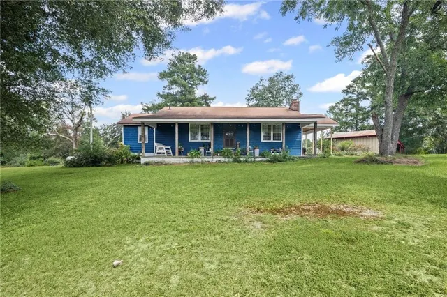 a front view of a house with a yard table and chairs