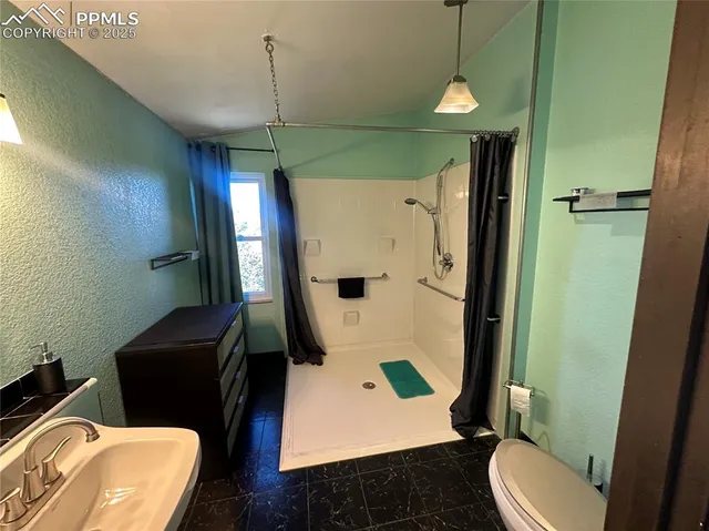 a bathroom with a toilet sink and shower