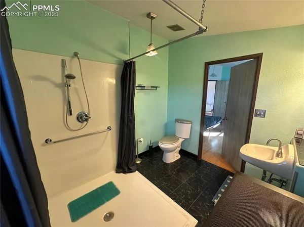 a bathroom with a toilet a sink and shower