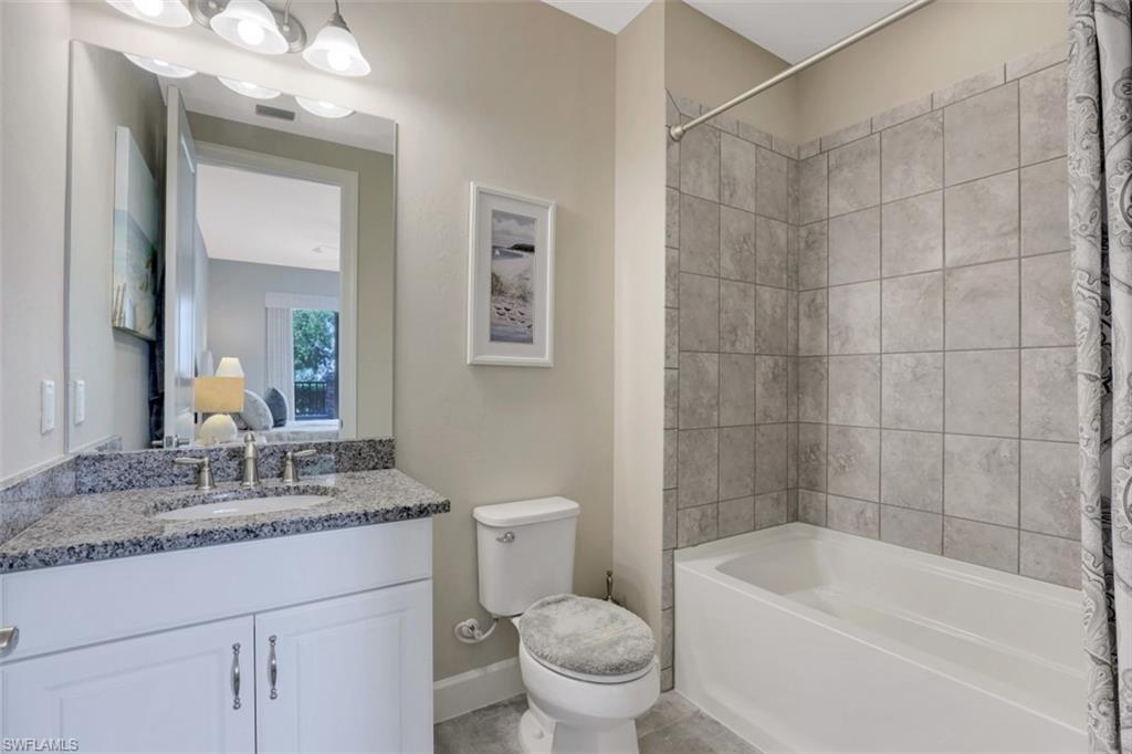 8776 Bellano Court, Unit 104 Naples, FL 34119 - Photo 15 of 34 a bathroom with a granite countertop sink a toilet and shower