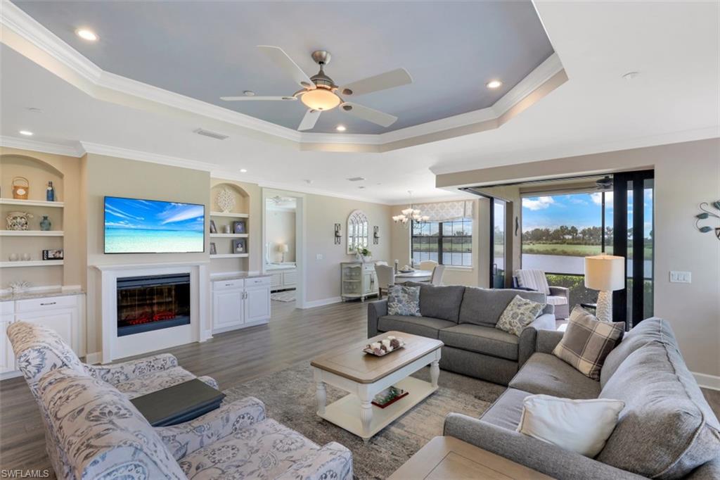 8776 Bellano Court, Unit 104 Naples, FL 34119 - Photo 2 of 34 a living room with furniture ceiling fan and a fireplace