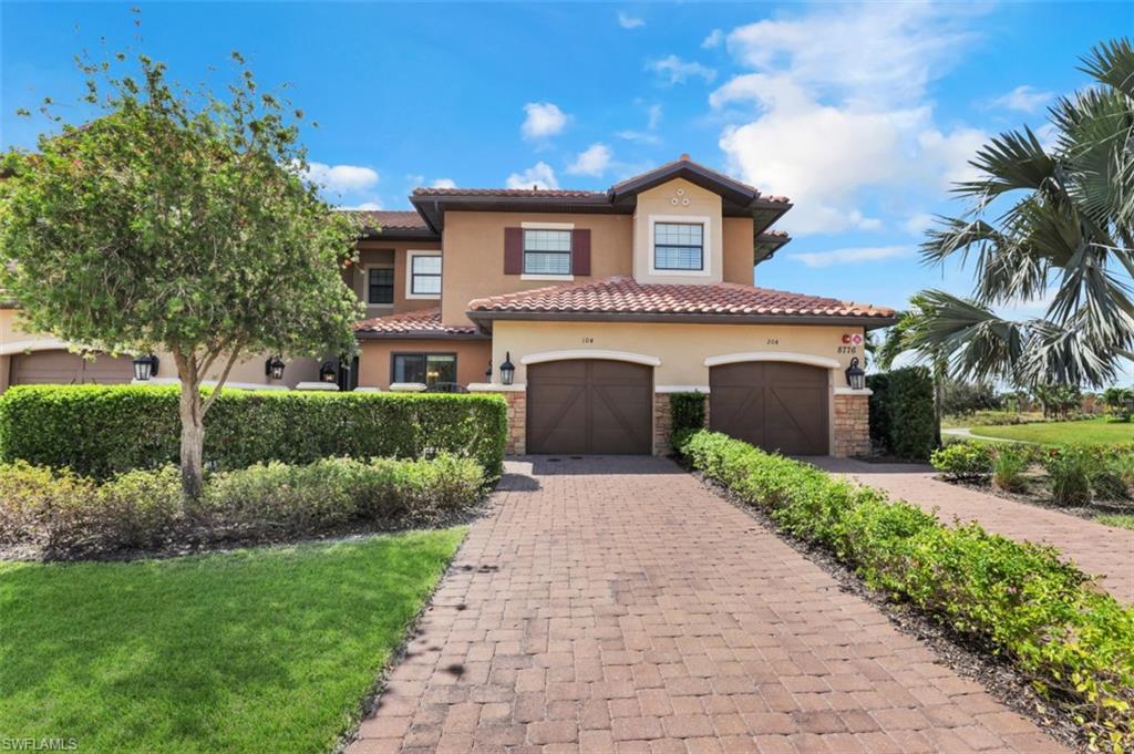 8776 Bellano Court, Unit 104 Naples, FL 34119 - Photo 21 of 34 a front view of a house with a yard and potted plants