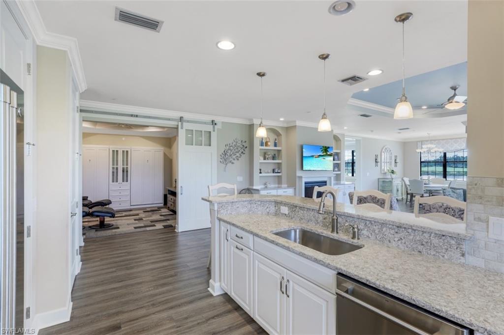 8776 Bellano Court, Unit 104 Naples, FL 34119 - Photo 7 of 34 a large kitchen with stainless steel appliances a large counter top a stove and a sink