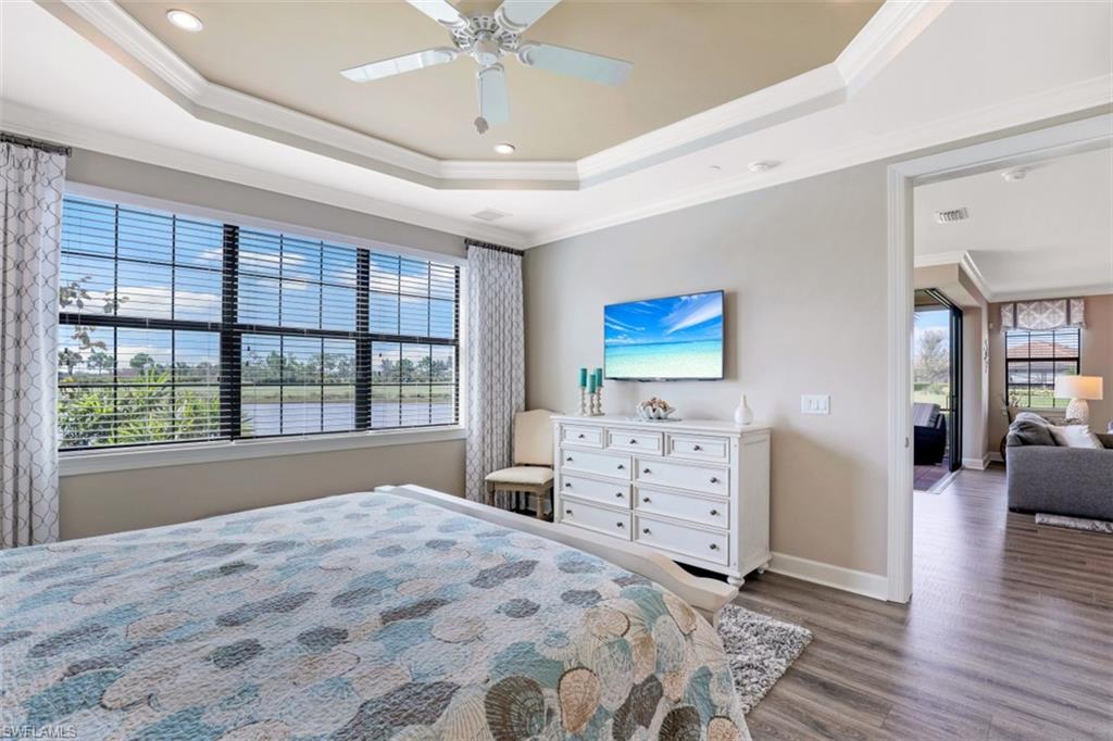 8776 Bellano Court, Unit 104 Naples, FL 34119 - Photo 10 of 34 a bedroom with a bed and a large window