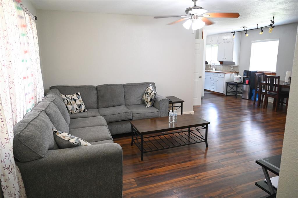 1352 Simpson Drive Hurst, TX 76053 - Photo 30 of 40 Spacious living area featuring wood-finish flooring, a ceiling fan, and white walls