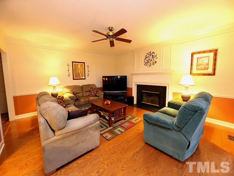 2108 Osprey Circle Raleigh, NC 27615 - Photo 6 of 15 a living room with furniture a flat screen tv and a fireplace
