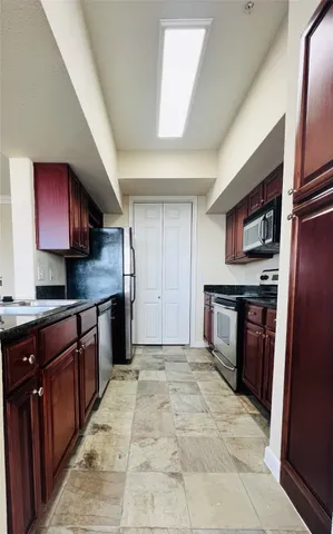 a large kitchen with stainless steel appliances granite countertop a refrigerator and a sink