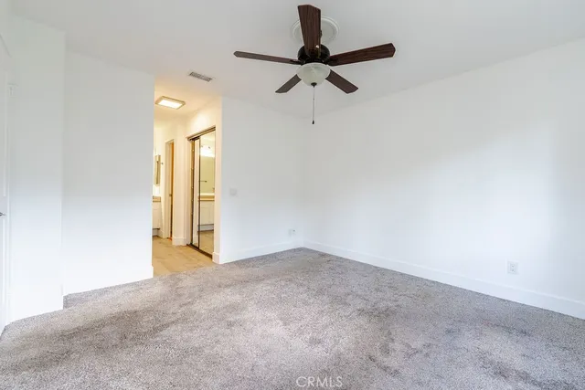 an empty room with a window and a fan