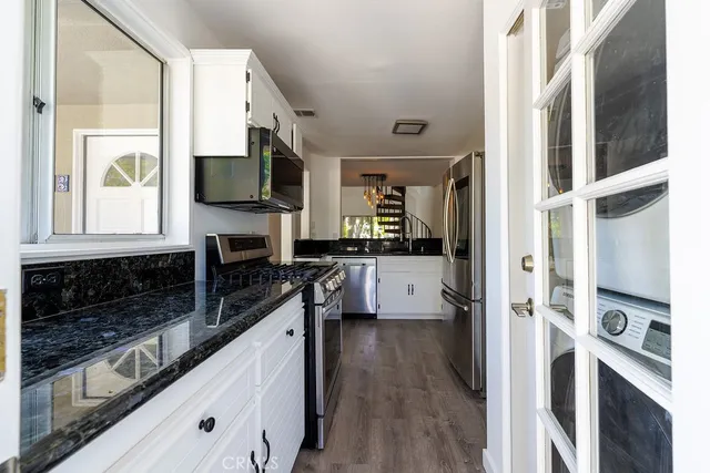 a kitchen with stainless steel appliances granite countertop a stove and a sink