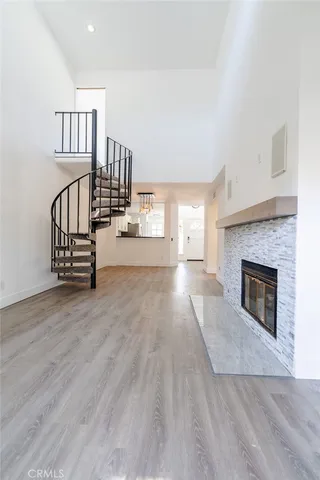 a view of a livingroom with wooden floor a fireplace and entryway