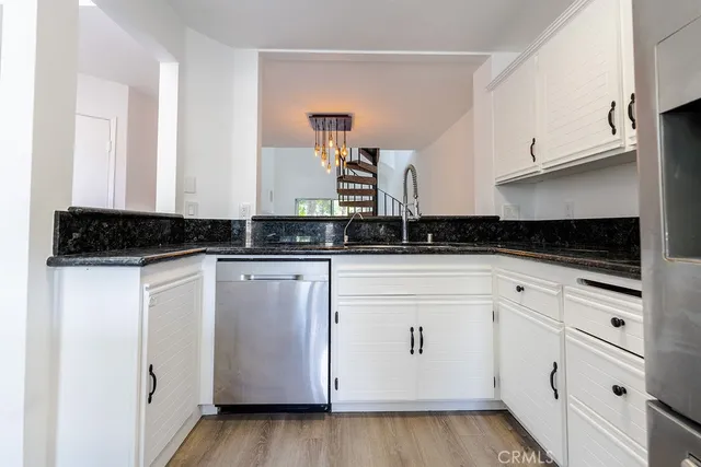 a kitchen with stainless steel appliances granite countertop a refrigerator and a stove top oven