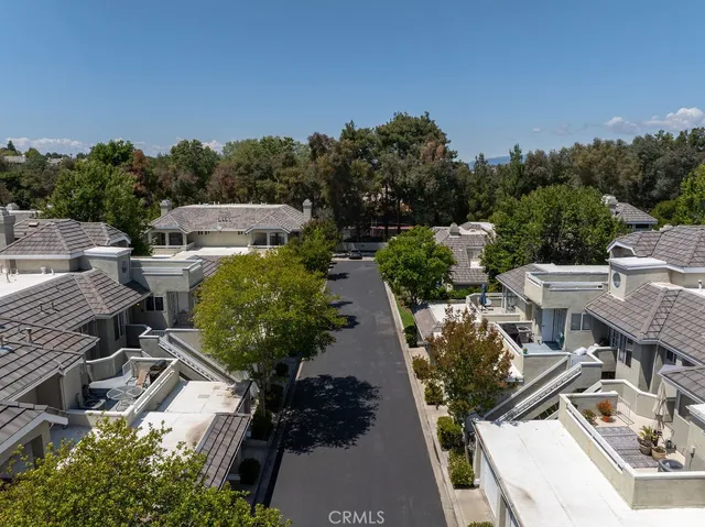 a view of a patio with table and chairs under an umbrella with wooden floor and fence