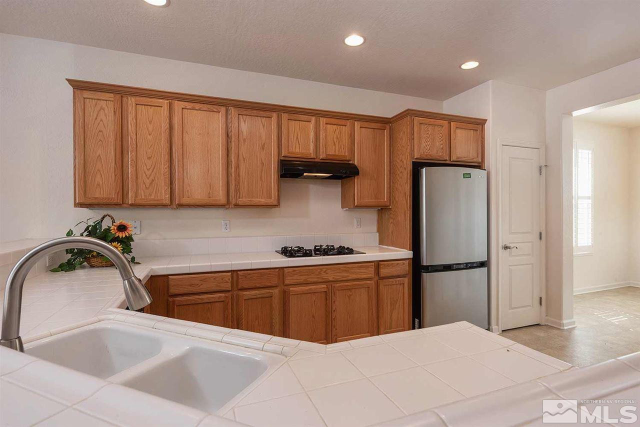 1540 Meridian Ranch Drive Reno, NV 89523 - Photo 8 of 25 a kitchen with a sink a refrigerator and cabinets