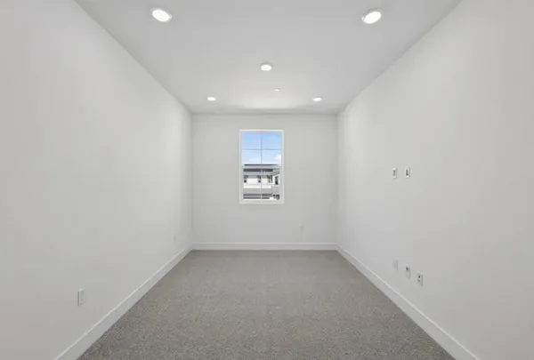 a large kitchen with stainless steel appliances granite countertop a stove a sink a refrigerator and white cabinets with wooden floor