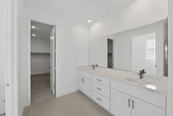a kitchen with a sink wooden floor and white cabinets