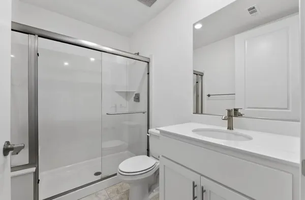 a bathroom with a sink a toilet and shower