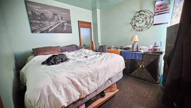 a bedroom with bed and a clock on the wall