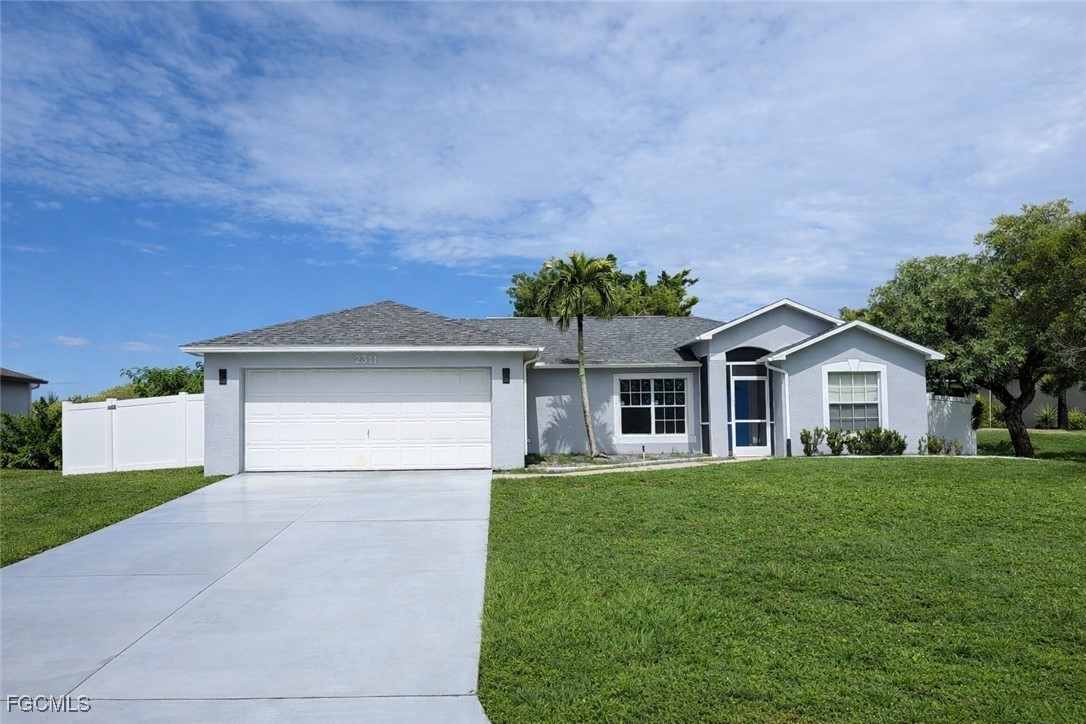 2311 Southwest 16th Terrace Cape Coral, FL 33991 - Photo 1 of 23 a front view of a house with a yard and garage