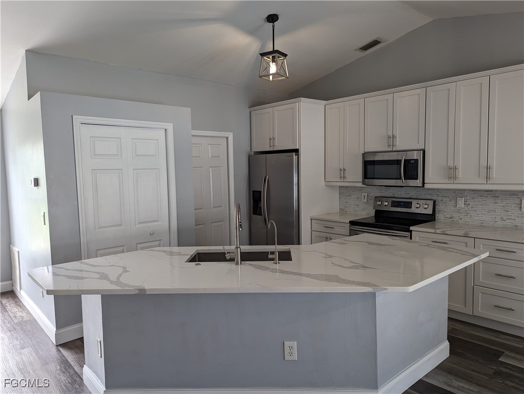 2311 Southwest 16th Terrace Cape Coral, FL 33991 - Photo 9 of 23 a kitchen with kitchen island a sink stainless steel appliances and counter space