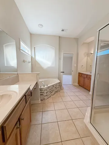 a spacious bathroom with a granite countertop sink a mirror and a shower