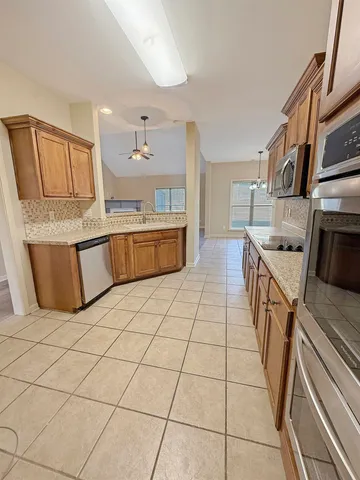 a kitchen with stainless steel appliances granite countertop a sink and cabinets