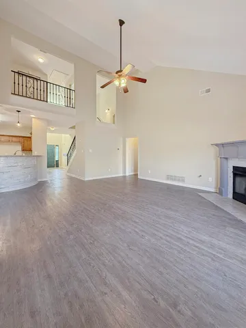 a view of an empty room with a window and wooden floor