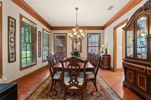 a view of a dining room with furniture large windows and wooden floor
