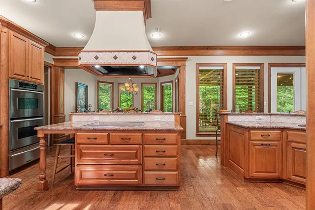 a kitchen with kitchen island granite countertop a stove and a sink