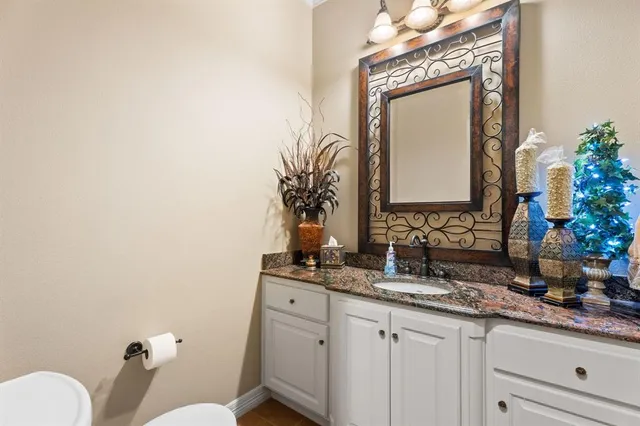 a spacious bathroom with a granite countertop double vanity sink a mirror and a bathtub