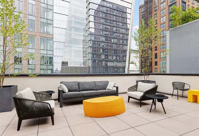 a roof deck with couch and chairs