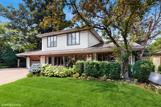 a front view of a house with a garden and plants