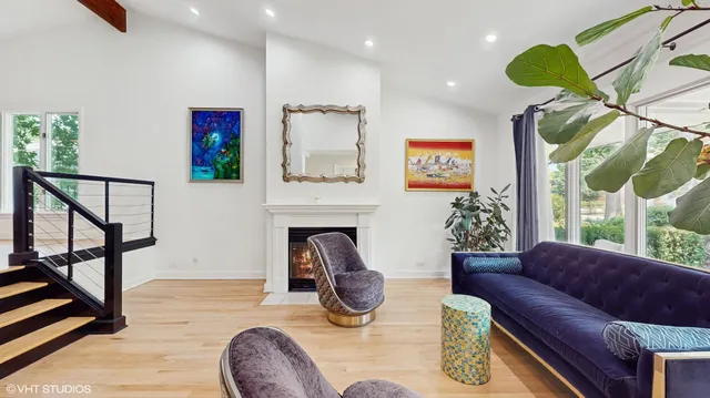 a living room with furniture a floor to ceiling window and a fireplace