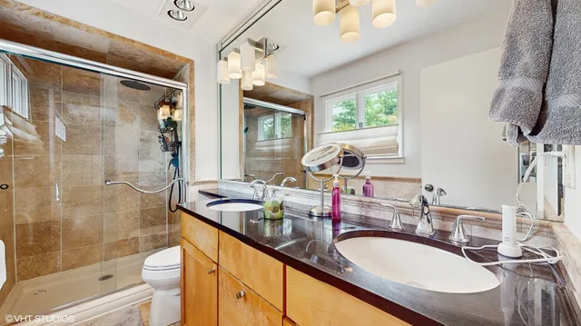 a bathroom with a granite countertop sink mirror and a bathtub