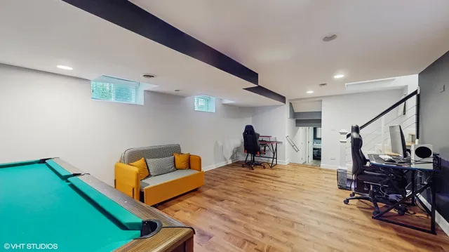 a room with furniture pool table gym equipment wooden floor and a view of kitchen