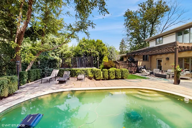 a view of swimming pool with outdoor seating and house in the background