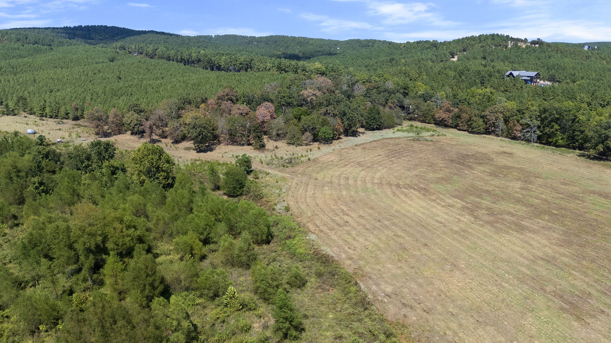 0 Rutty Pne Ridge Broken Bow, OK 74728 - Photo 13 of 22 Expansive rural property featuring a large open field, dense mature tree lines, and distant rolling hills