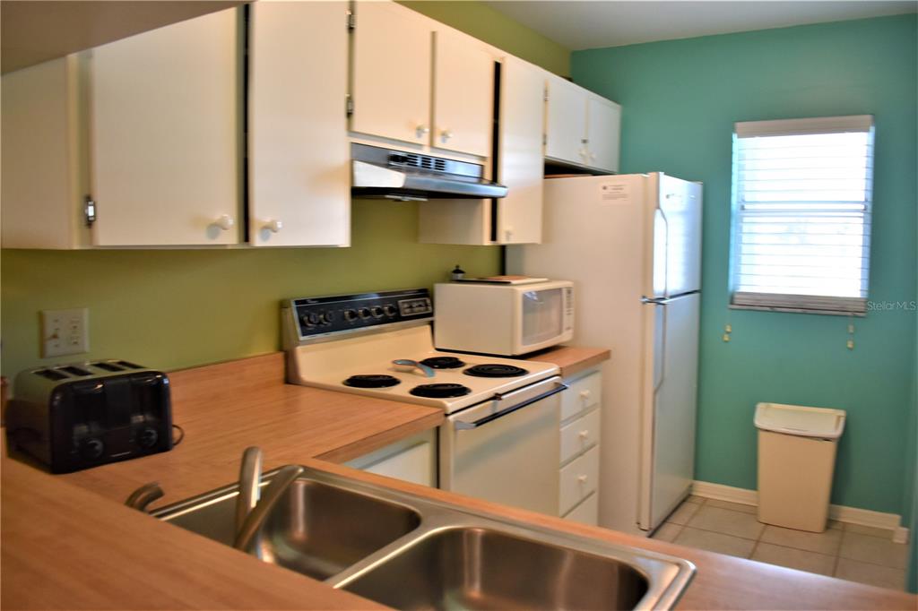 448 Cerromar Road, Unit 189 Venice, FL 34293 - Photo 15 of 48 a kitchen with stainless steel appliances a stove a sink and a refrigerator