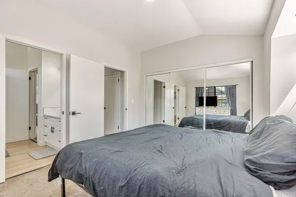 a bedroom with a large bed and a large mirror