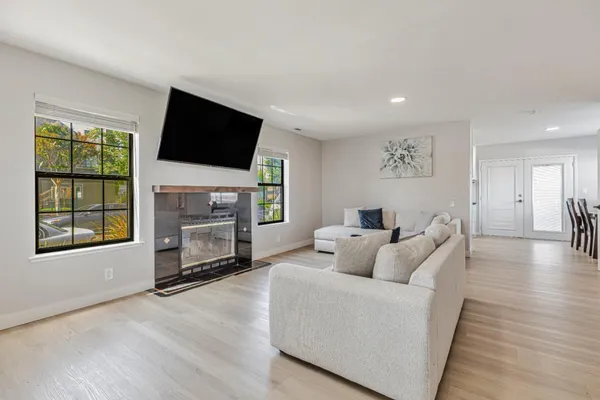 a living room with furniture a flat screen tv and a fireplace