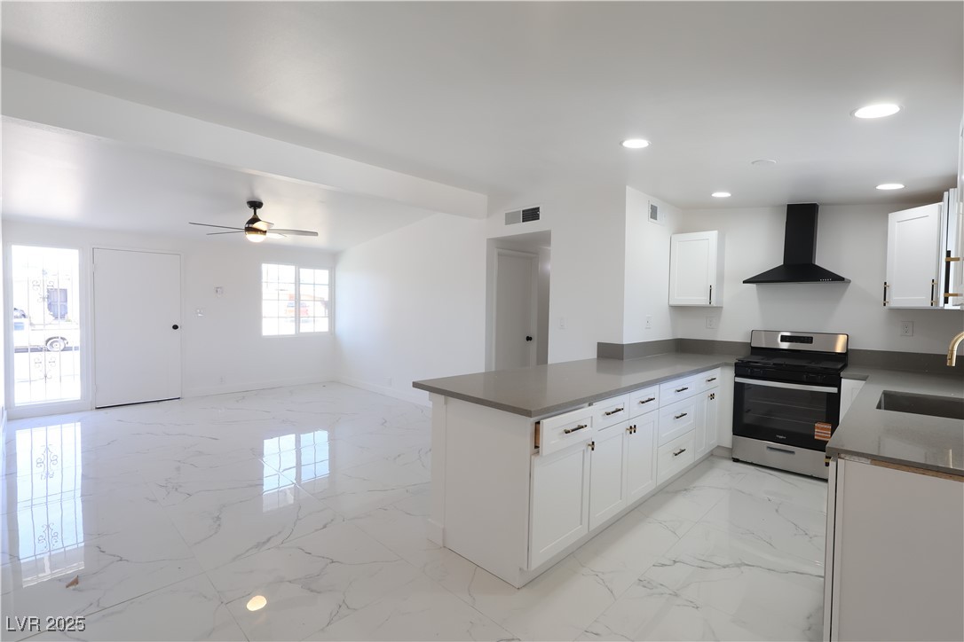 3115 Wright Avenue North Las Vegas, NV 89030 - Photo 4 of 20 Kitchen with wall chimney range hood, a peninsula,