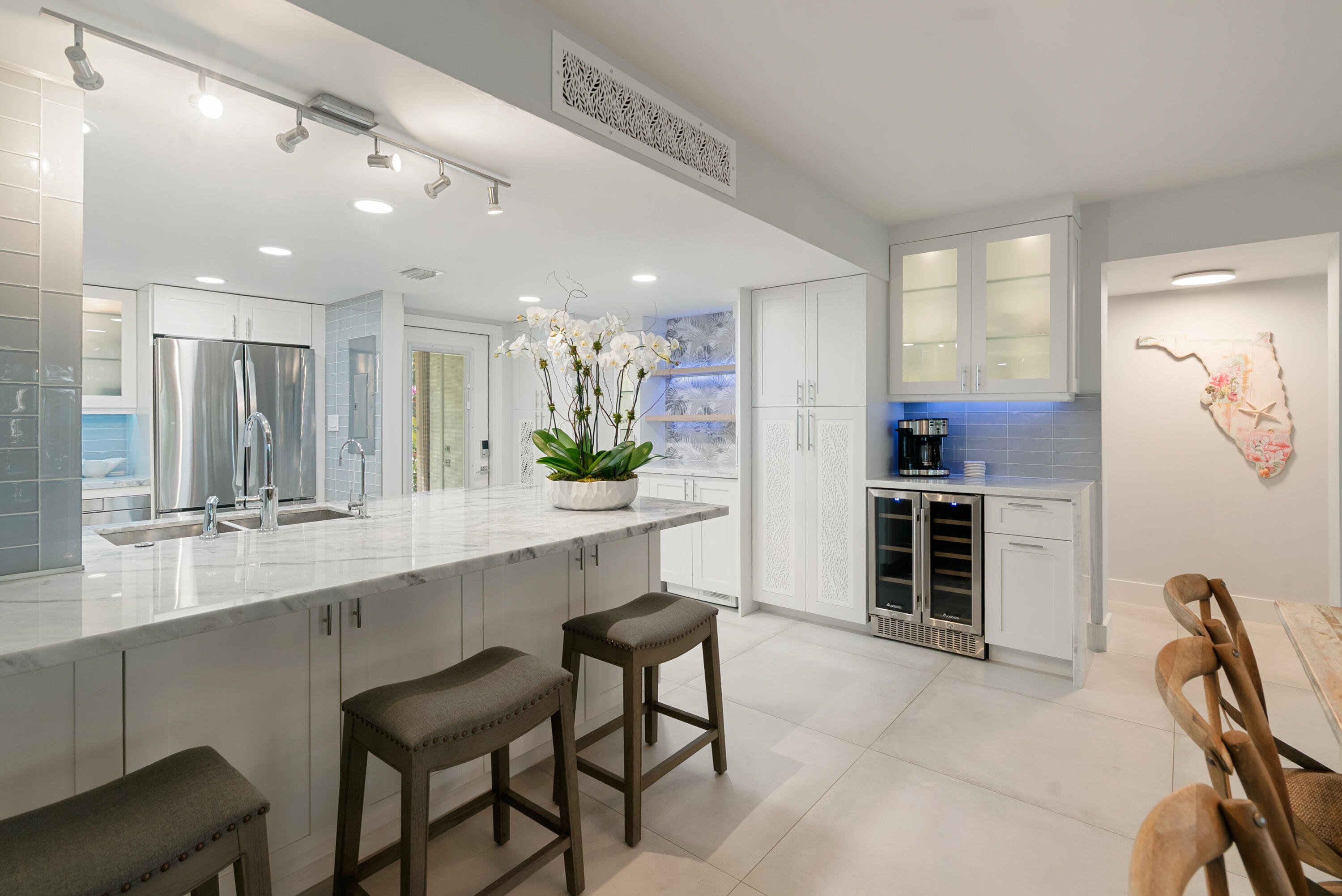 97652 Overseas Highway, Unit M4 Key Largo, FL 33037 - Photo 11 of 44 a room with stainless steel appliances kitchen island granite countertop a table chairs in it and wooden floors