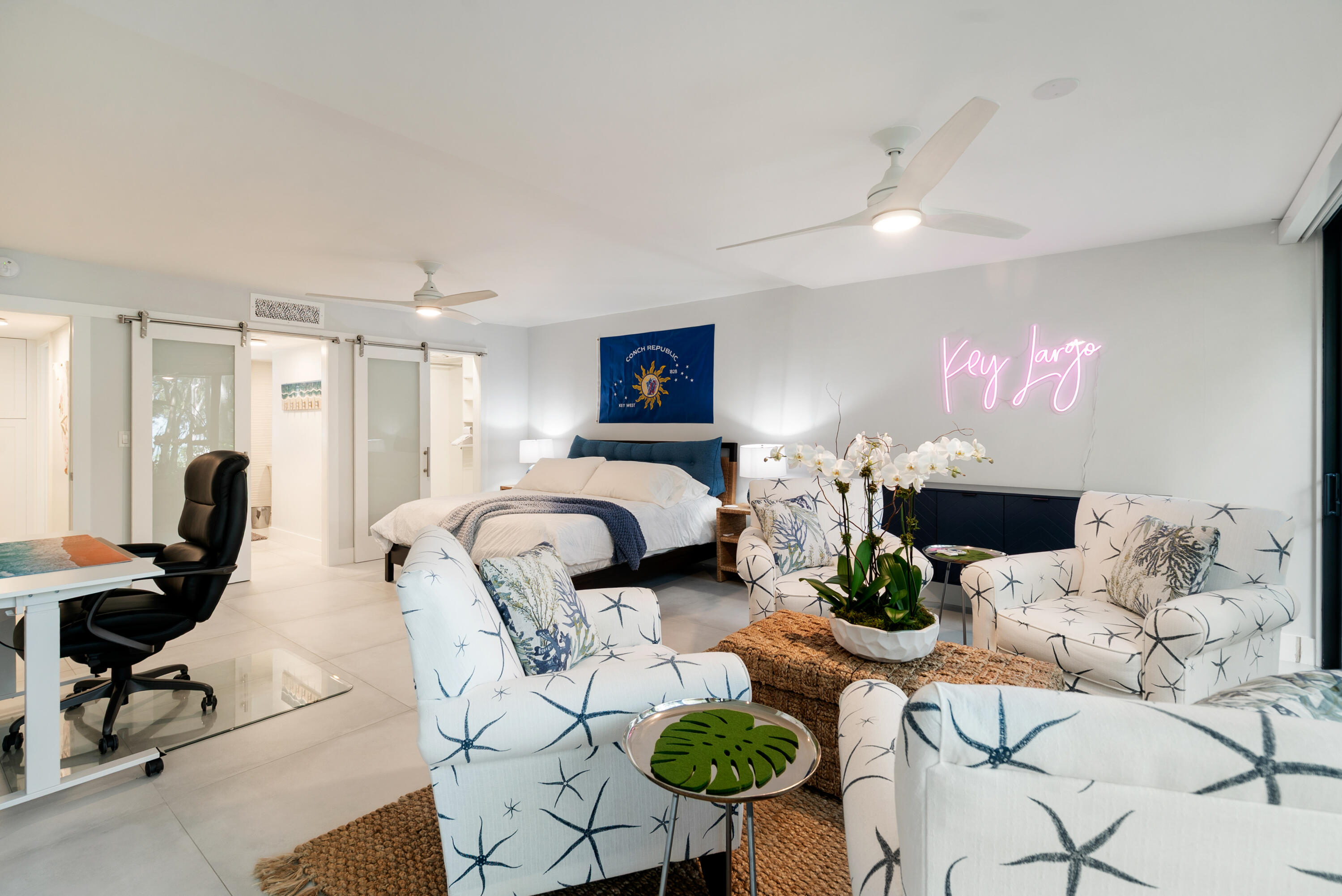 97652 Overseas Highway, Unit M4 Key Largo, FL 33037 - Photo 17 of 44 a bedroom with furniture and a chandelier