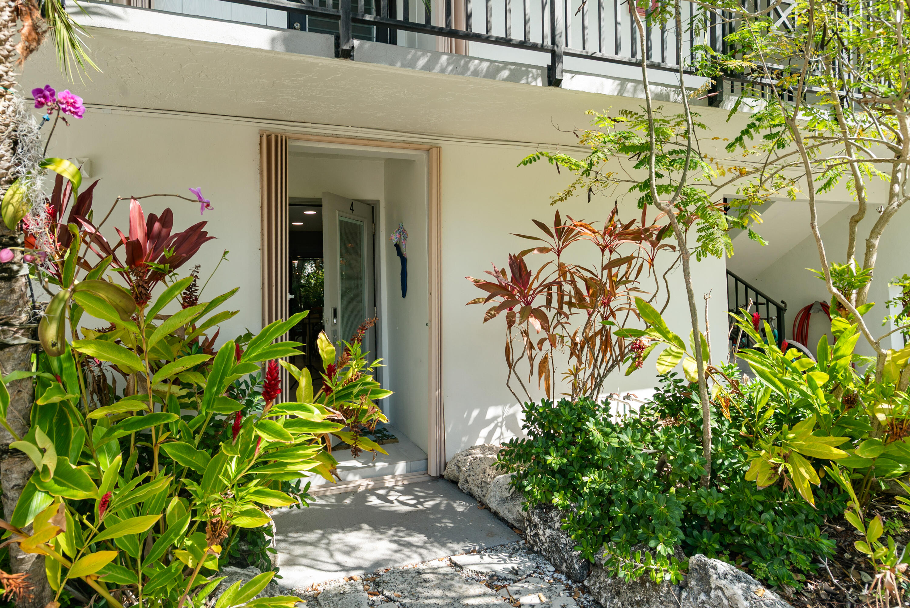97652 Overseas Highway, Unit M4 Key Largo, FL 33037 - Photo 26 of 44 a front view of a house with a lot of flowers