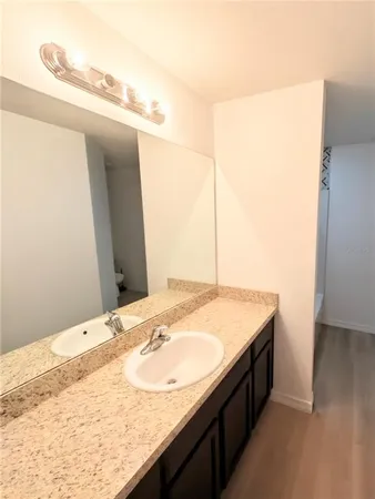 a bathroom with a granite countertop sink and a mirror