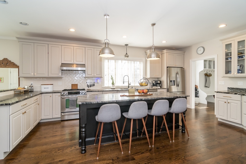 6 Hickory Road Natick, MA 01760 - Photo 8 of 35 a large kitchen with kitchen island granite countertop a table chairs sink and cabinets
