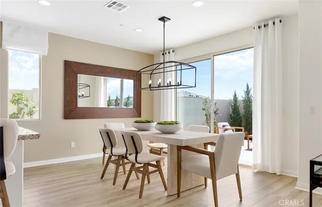 a dining room with furniture a chandelier and wooden floor