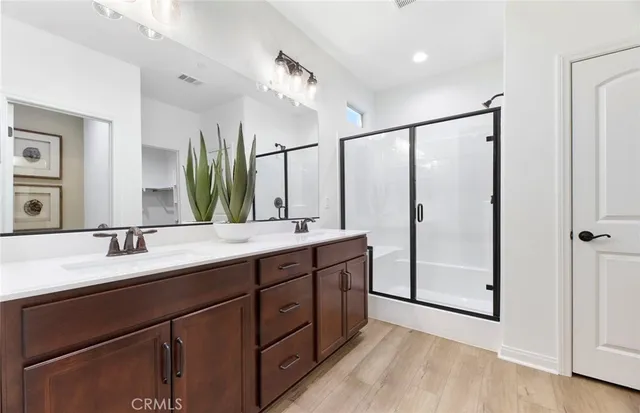 a bathroom with a double vanity sink mirror and shower